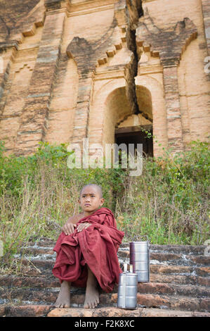 Burmese Monk sitting in front of Mingun Pagoda - Mandalay, Myanmar Stock Photo