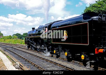 Steam Locomotive British Rail Standard Class 5 4-6-0 number 73129 in British Rail Black leaving the railway station, Arley. Stock Photo