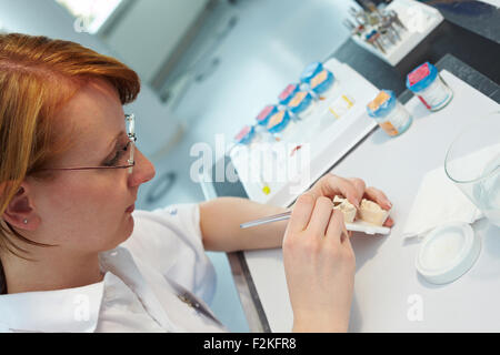 Dental technician working on ceramic inlays in a lab Stock Photo