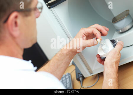 Dental technician placing a dental model in a 3D scanner Stock Photo