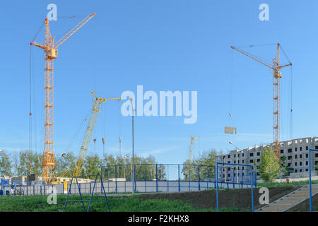 Several cranes on the construction site of the house. Stock Photo
