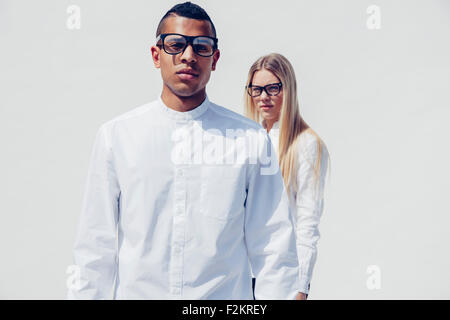 Portrait of stylish young couple wearing matching clothes in front of white background Stock Photo