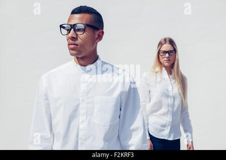 Portrait of stylish young couple wearing matching clothes in front of white background Stock Photo