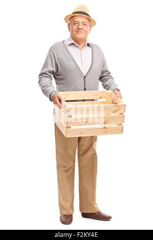 Full length portrait of a senior gentleman holding an empty wooden crate and looking at the camera isolated on white background Stock Photo