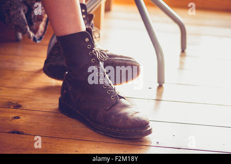Young woman's feet resting on wooden floor Stock Photo