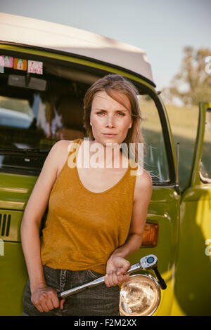 Woman holding a torque wrench at van Stock Photo