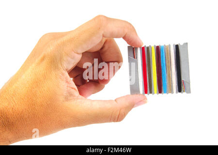 Hand with sewing threads multicolored isolated on a white background Stock Photo