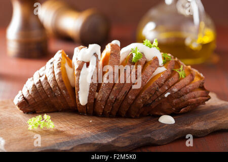 Baked hasselback potatoes with sour cream Stock Photo