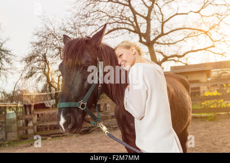 Woman with horse on a paddock Stock Photo