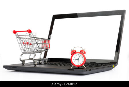 Shopping cart and alarm clock on laptop Stock Photo