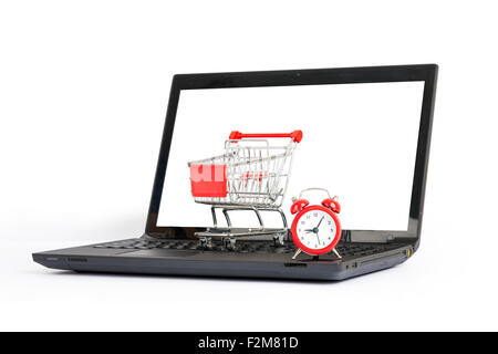 Shopping cart, alarm clock on laptop, close view Stock Photo