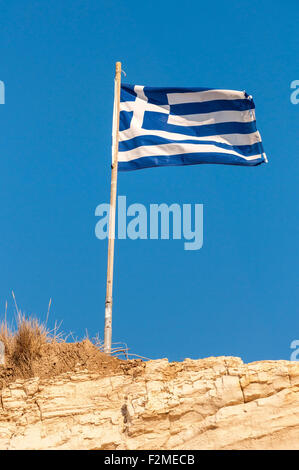Greek flag on a pole against blue sky Stock Photo