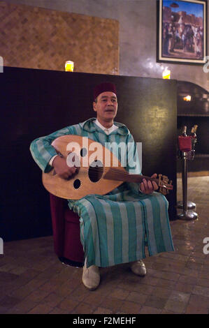Vertical portrait of a Moroccan man playing a traditional Oud. Stock Photo