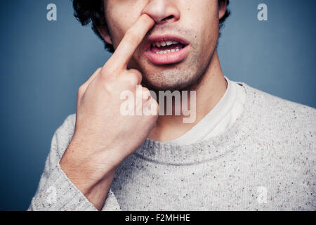 Young man picking his nose Stock Photo