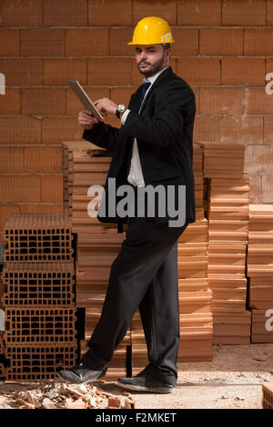 Portrait Of Construction Master With Personal Computer In Hands Stock Photo