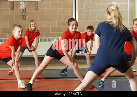 Teacher Taking Exercise Class In School Gym Stock Photo