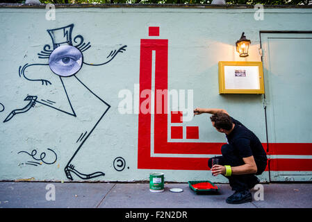 New York, NY 18 September 2015 - French Graffiti artist L'Atlas at work on a mural. His 'abstract calligraphy' creats a strong contrast to the work of French graffiti artist JR whose work appears on the right. Stock Photo
