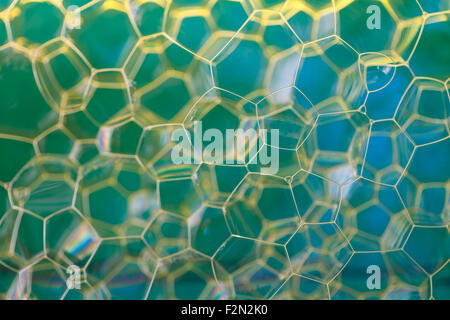 Soap suds extreme closeup creating honeycomb pattern of golden lines Stock Photo