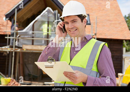 Architect On Building Site Using Mobile Phone Stock Photo