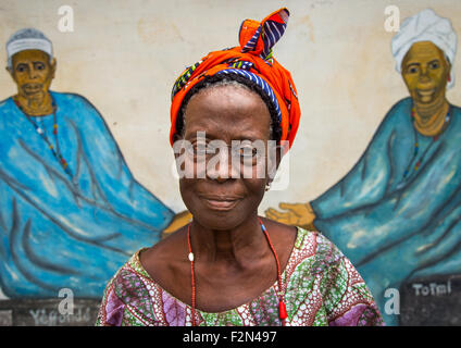 Benin, West Africa, Savalou, a priestess from the voodoo covent of the royal palace in front of a painted wall Stock Photo