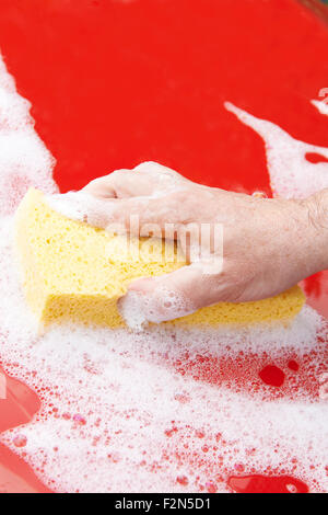 Close Up Of Hand Washing Car Hood Using Sponge Stock Photo