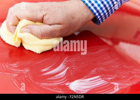 Close Up Of Hand Polishing Car Hood Using Cloth Stock Photo