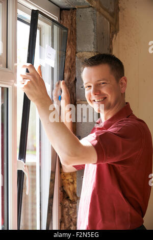 Construction Worker Installing New Windows In House Stock Photo