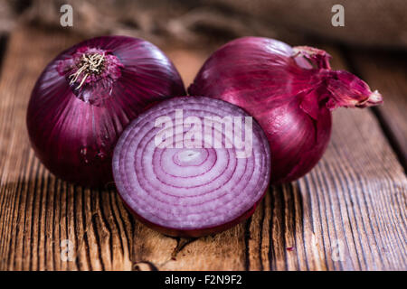Some fresh Red Onions (close-up shot) on an wooden table Stock Photo