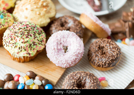 close up of glazed donuts and sweets on table Stock Photo