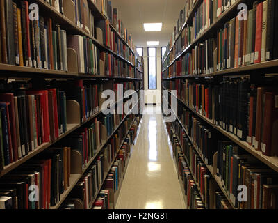 Aisle between shelves of library books, in an education background like ...