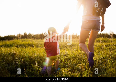 Mother and son walking in rural field Stock Photo