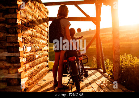 Mother holding son on motorcycle on patio Stock Photo