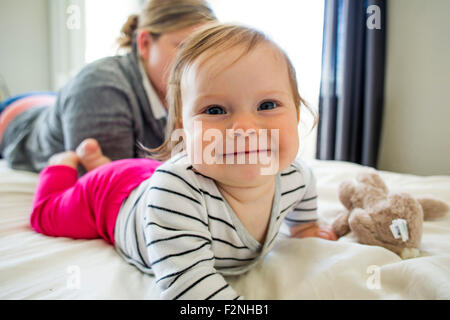 Caucasian mother and baby girl laying on bed Stock Photo