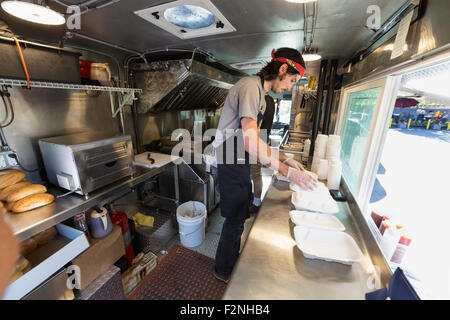Caucasian chef working in food truck kitchen Stock Photo