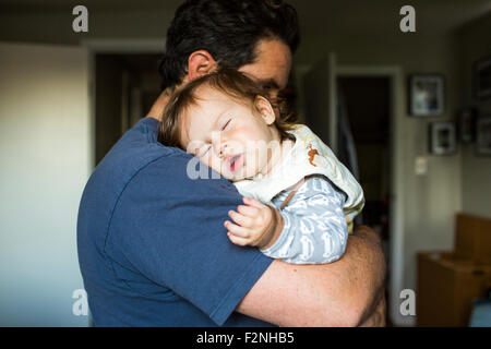 Caucasian father holding sleeping baby girl Stock Photo