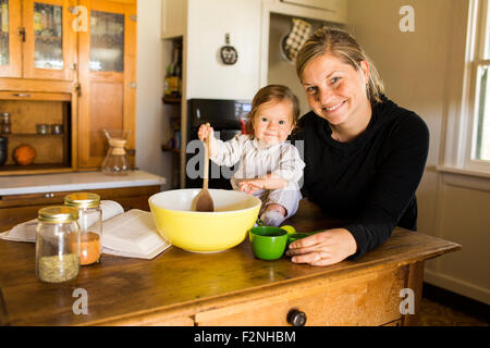 Caucasian mother and baby girl baking in kitchen Stock Photo