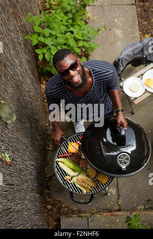 High angle view of African American man grilling at barbecue Stock Photo
