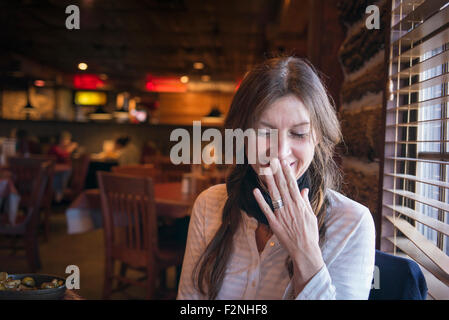 Caucasian woman laughing in bar Stock Photo