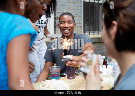 Friends celebrating birthday party in backyard Stock Photo