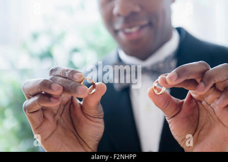 Close up of groom holding wedding rings Stock Photo