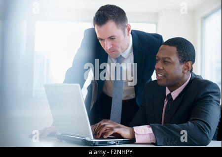 Businessmen using laptop in office Stock Photo