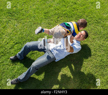 High angle view of Hispanic father and son playing on lawn Stock Photo