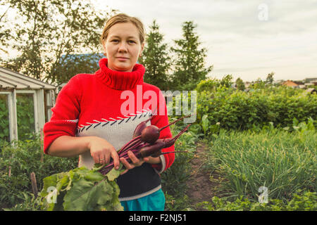 Caucasian farmer holding fresh beets in garden Stock Photo