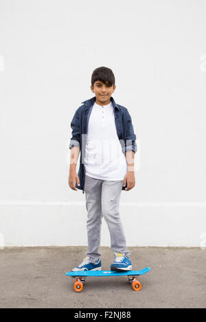 Asian boy standing on skateboard Stock Photo