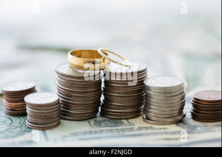 Close up of stacks of coins and wedding rings Stock Photo