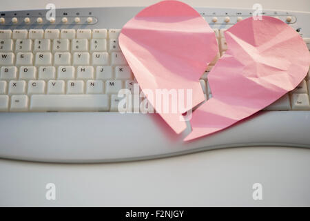 Close up of broken heart on computer keyboard Stock Photo
