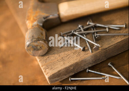 Close up of hammer, nails and wooden board Stock Photo