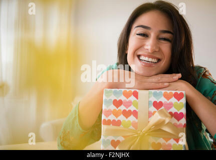 Close up of woman leaning on wrapped gift Stock Photo
