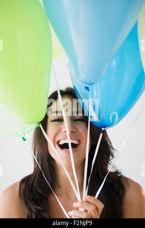 Close up of woman holding bunch of balloons Stock Photo