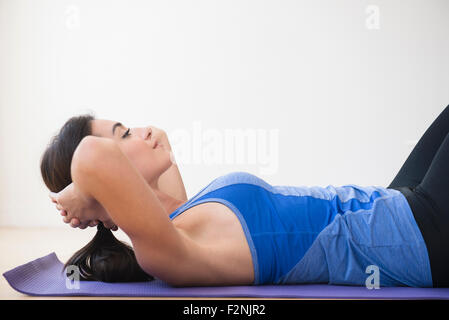 Woman doing crunches on exercise mat Stock Photo